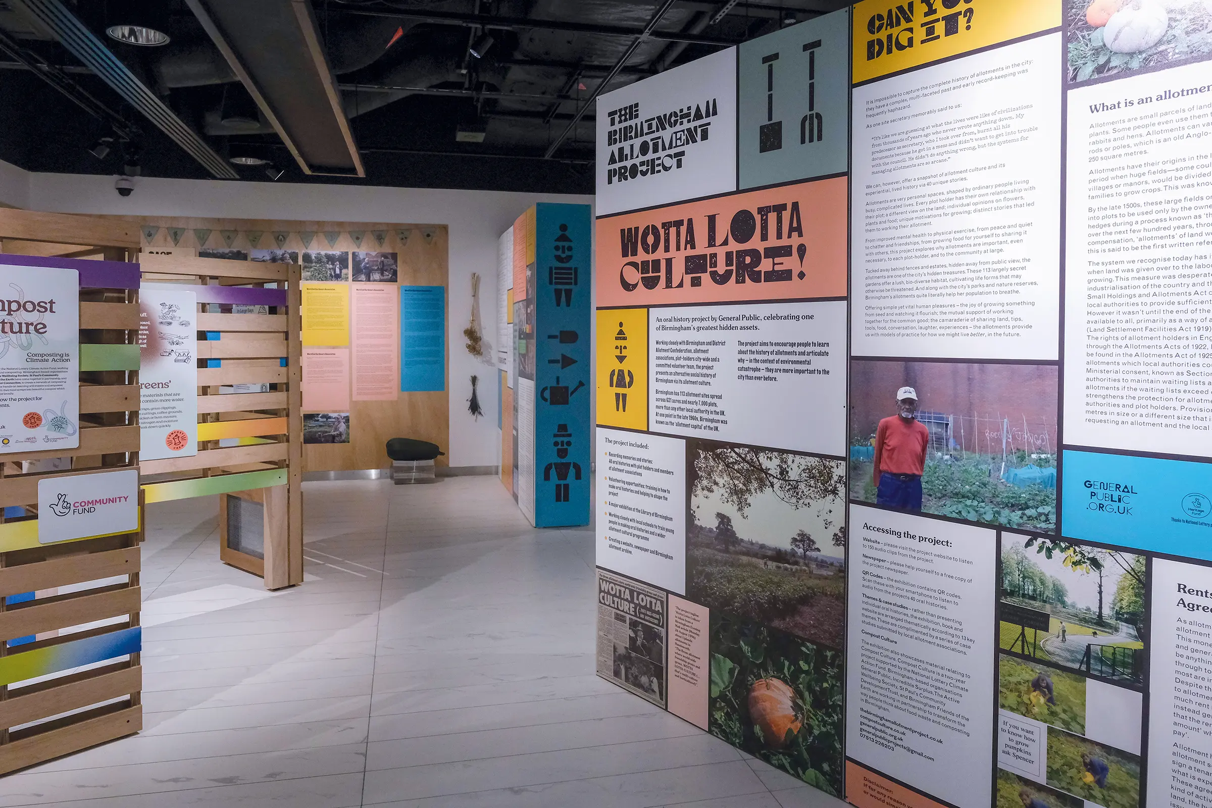 An image of multicolored exhibition panels, in a white gallery space. The text on the main panel reads 'The Birmingham Allotment Project' and 'WOTTA LOTTA CULTURE!
