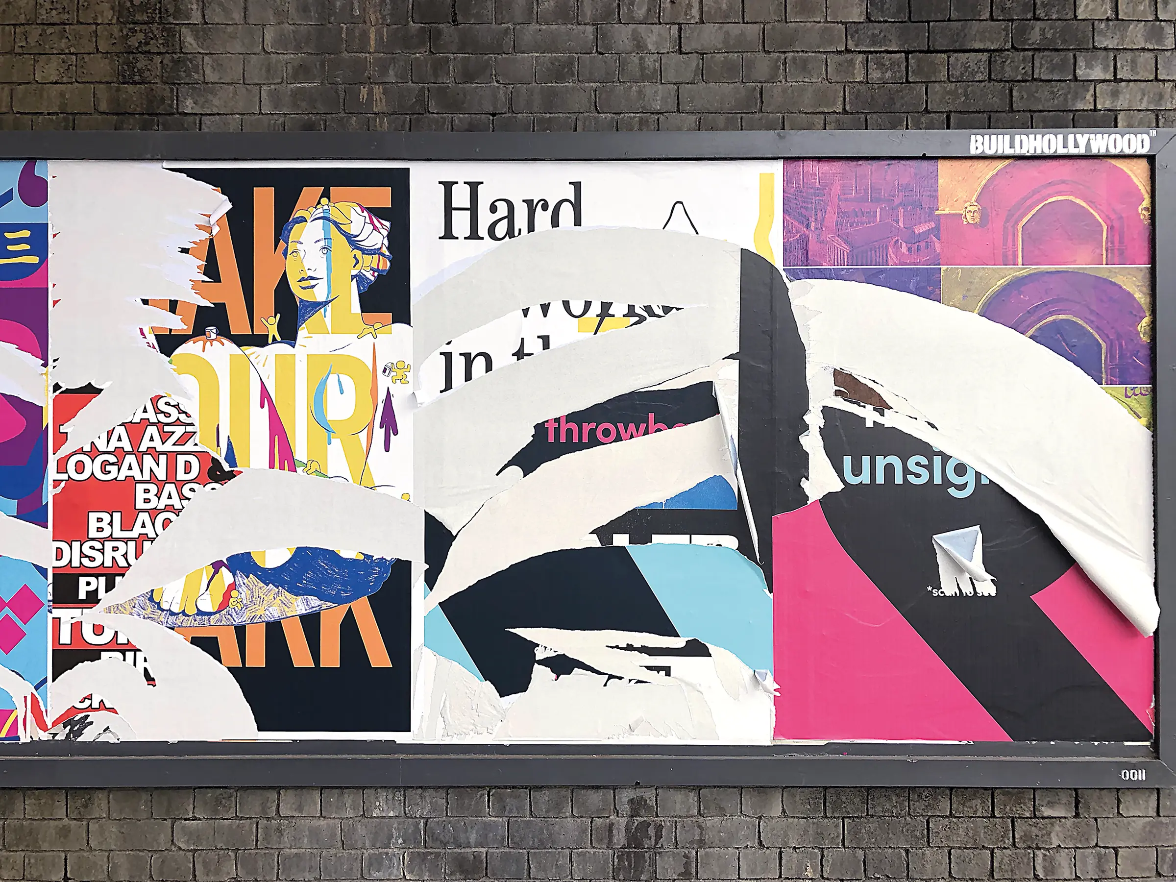 A selection of torn posters on an outdoor poster site, with the remnants of the poster from the following slide visible in the middle. 