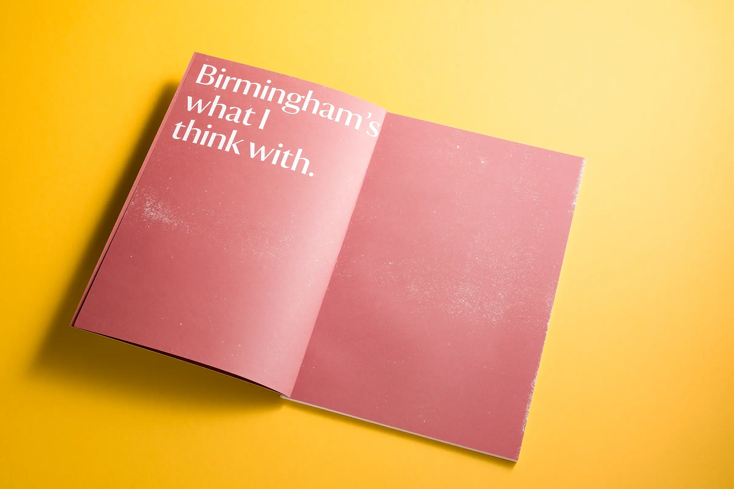 An image of a white brochure for National Trust Birmingham, lying on a bright yellow background